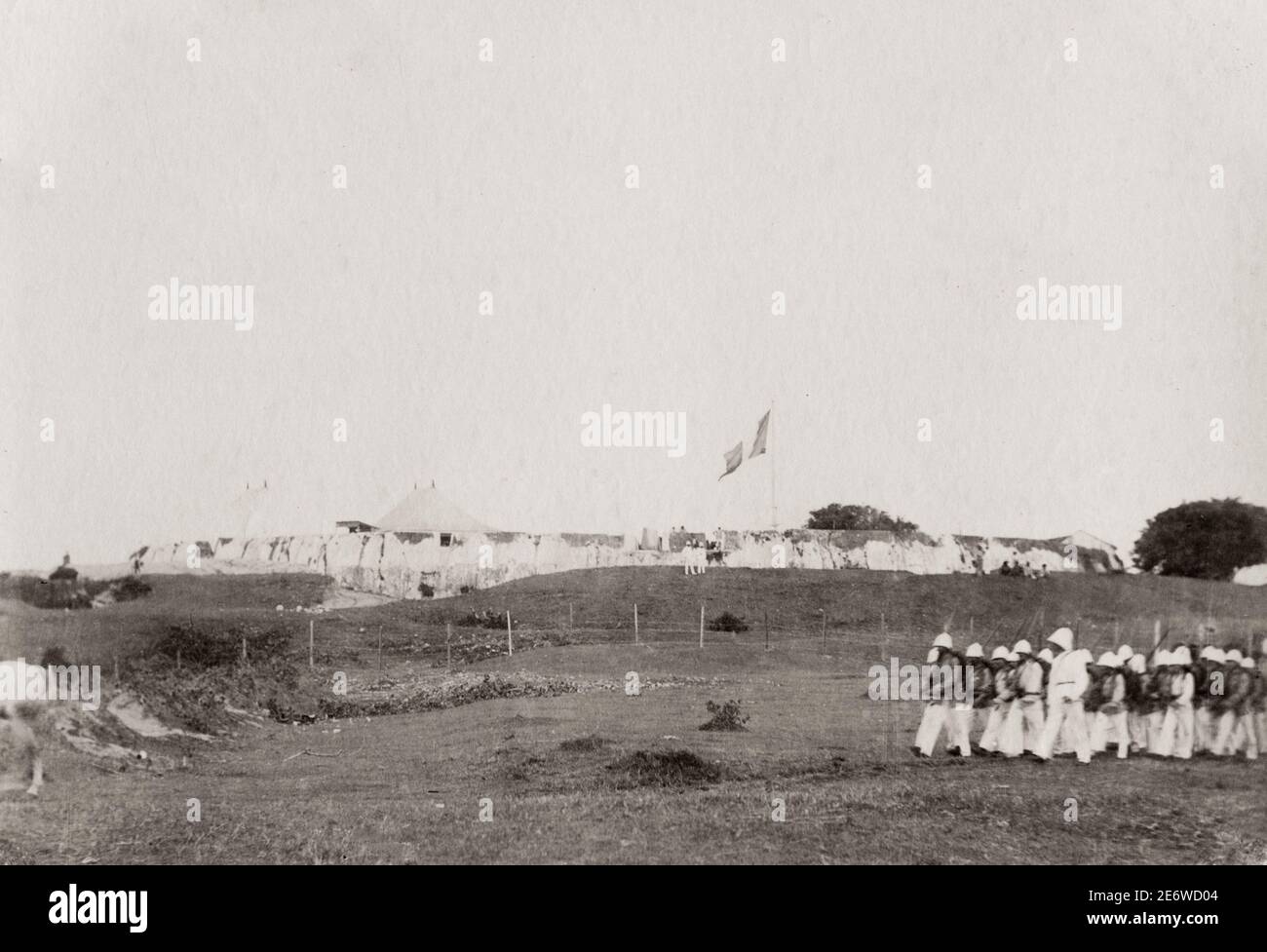 Vintage 19th century photograph: Captioned 'Hova Fort' Tamatave, Toamasina, Madagascar, French soldiers marching past; presumably Fort Manda. Stock Photo