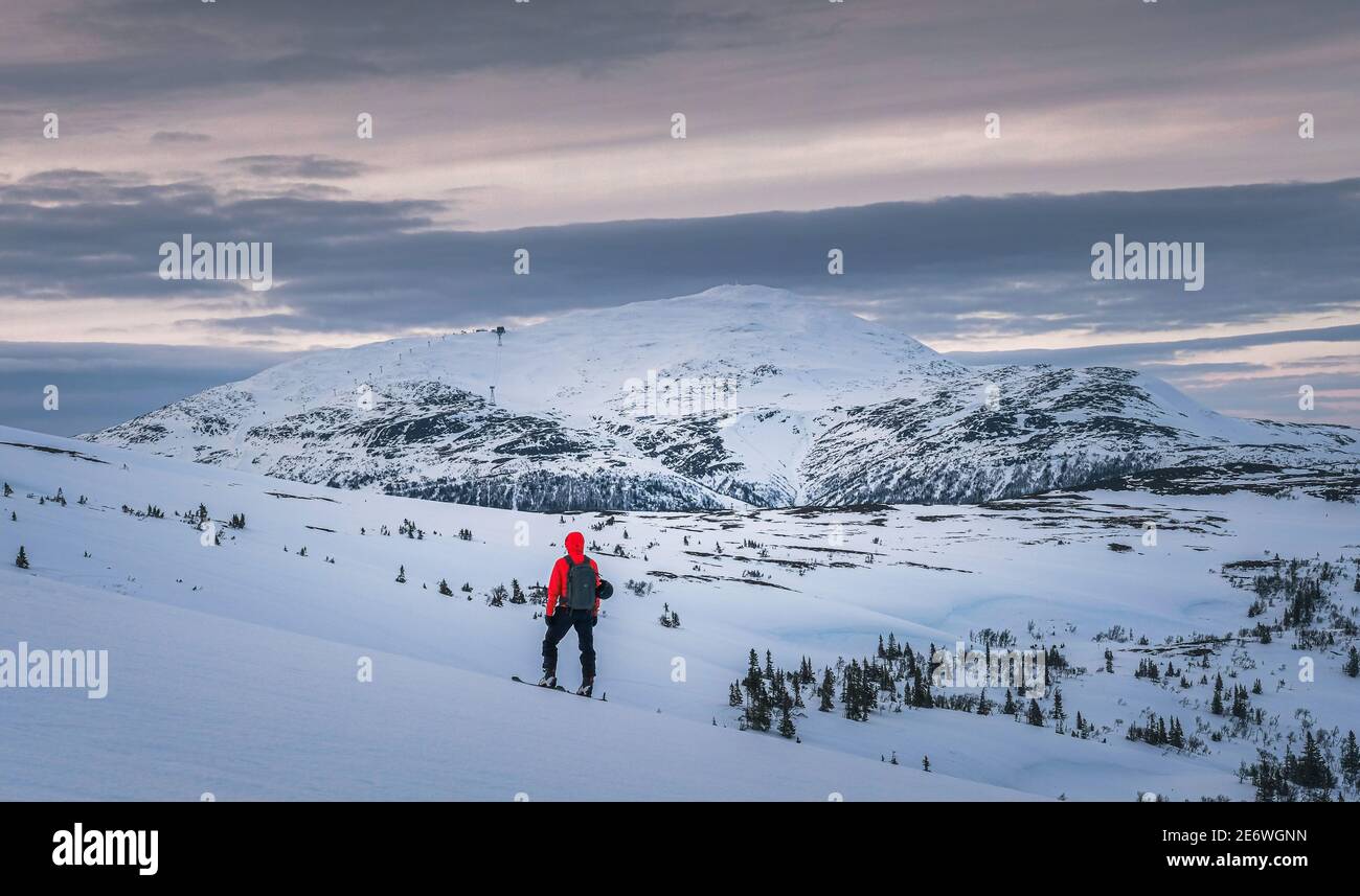 Back view of a traveler enjoying the mesmerizing winter mountainscape Stock Photo