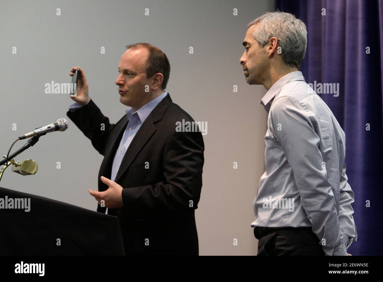 John Harrobin (L), senior vice president of digital media and marketing for Verizon  Wireless, holds up his mobile phone as Russ Shaw, general manager of Mobile  for Skype, looks on during a