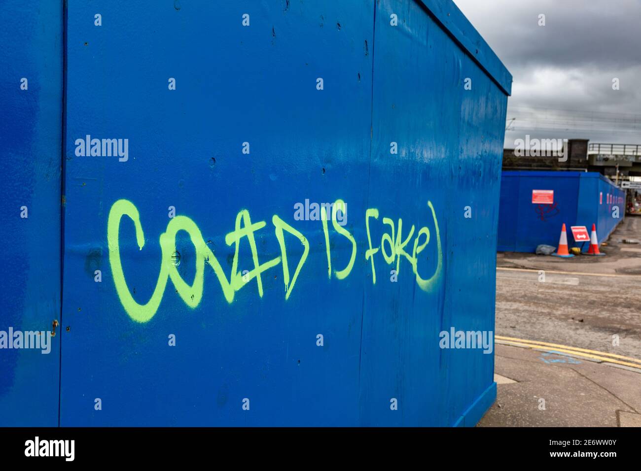 Covid is fake grafitti on a hoarding, 2021 Stock Photo