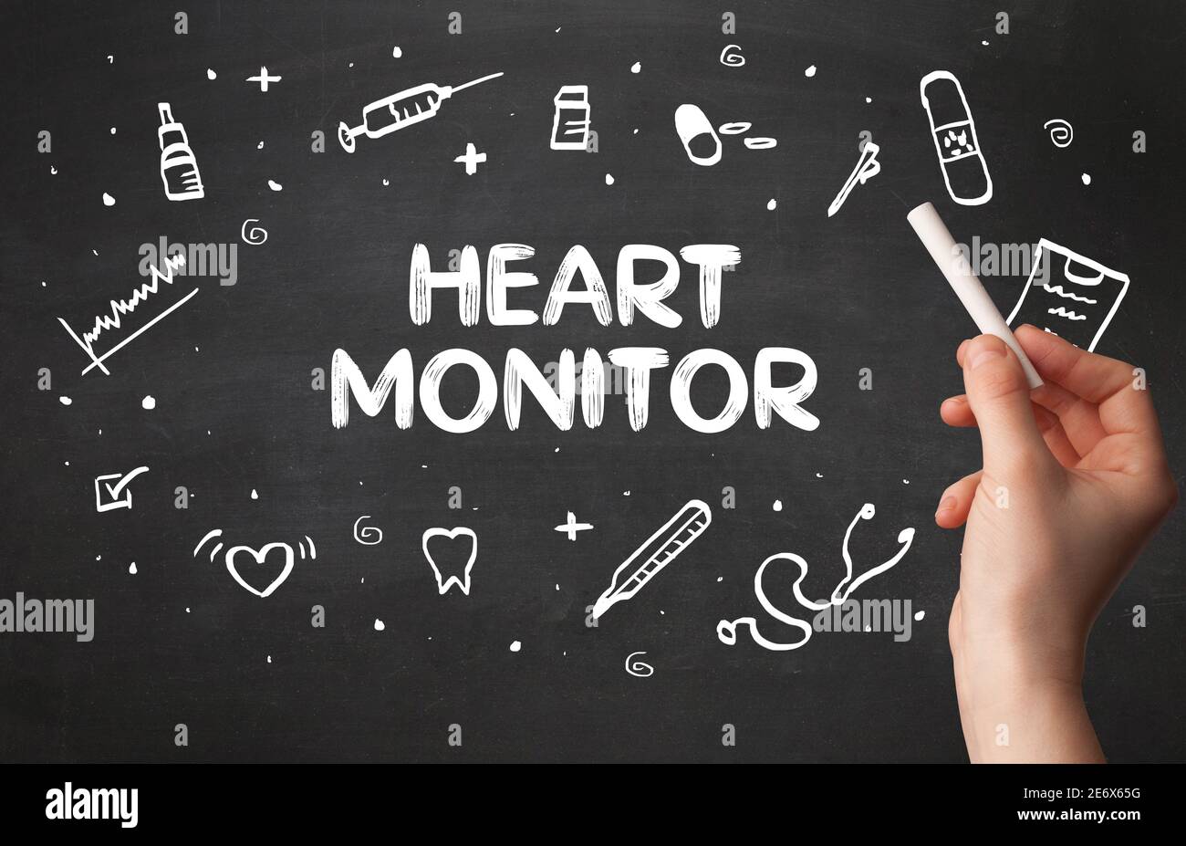 Hand drawing HEART MONITOR inscription with white chalk on blackboard