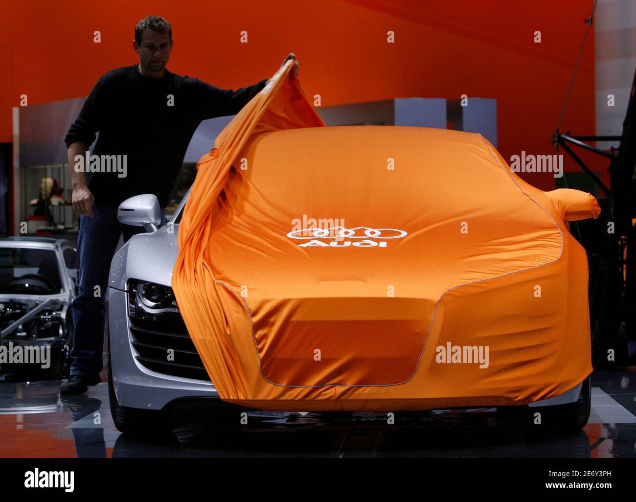 A staff removes a cover from an Audi R8 model on the last day of the  preparation of the 2007 Geneva car show in Geneva March 5, 2007.  REUTERS/Denis Balibouse (SWITZERLAND Stock