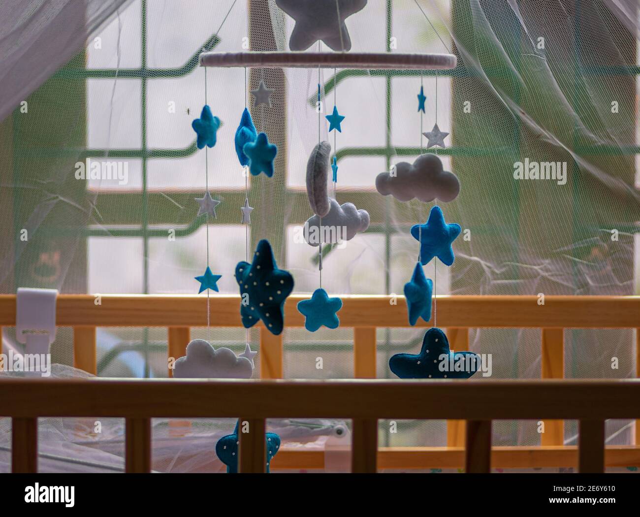 Cot mobile over the babies small bed has purple net over and the baby
