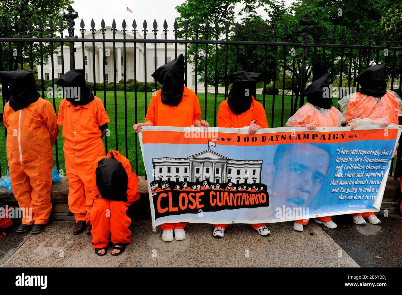 Demonstrators in orange jail jumpsuits and black hoods hold a vigil outside the White House to mark the 100th day of President Barack Obama's administration and his promise to close the military prison facility in Guantanamo Bay, Cuba, in Washington, April 29, 2009.      REUTERS/Mike Theiler   (UNITED STATES CONFLICT POLITICS) Stock Photo