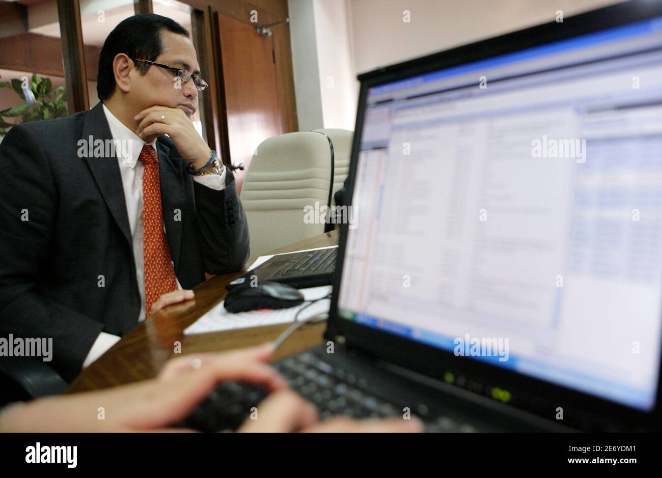 National Treasurer Roberto Tan reads questions from the Dealing Room, a Reuters Messaging chatroom, during an interview in Manila January 25, 2010. The Philippines may complete its foreign debt issues for this year by March if market conditions are good, Tan said on Monday.  REUTERS/Cheryl Ravelo  (PHILIPPINES - Tags: BUSINESS) Stock Photo