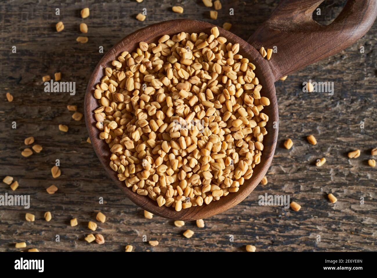 Dry fenugreek seeds on a big wooden spoon, top view Stock Photo