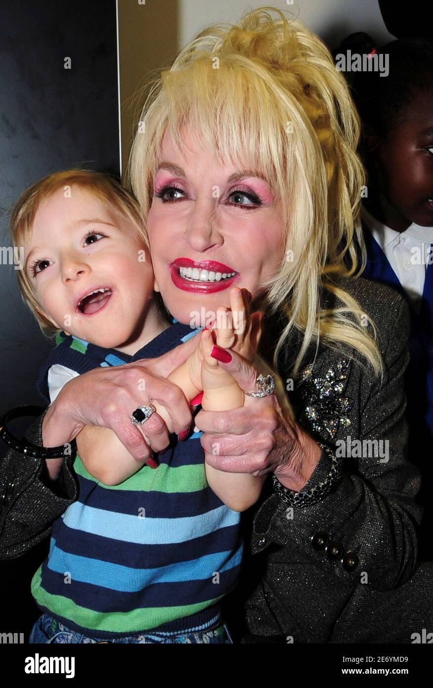 U.S. singer Dolly Parton (R) plays with a child during the launch of her Imagination  Library book project at the Magna Centre in Sheffield in northern England  December 5, 2007. Parton's Imagination