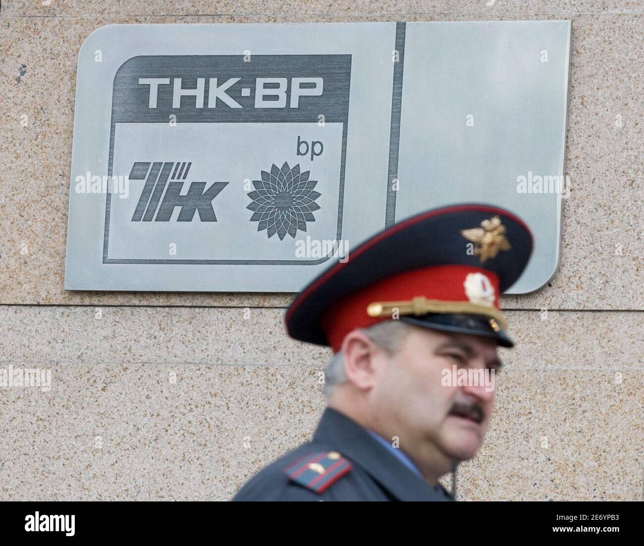 A police officer walks past a plaque of the oil firm TNK-BP at its headquarters in Moscow June 11, 2008. The four billionaire Russian shareholders in BP's troubled Russian joint venture, TNK-BP, said on Wednesday they would sue BP in a Stockholm court and launch separate legal actions in Moscow to strip BP-nominated TNK-BP directors of their powers.   REUTERS/Sergei Karpukhin  (RUSSIA) Stock Photo