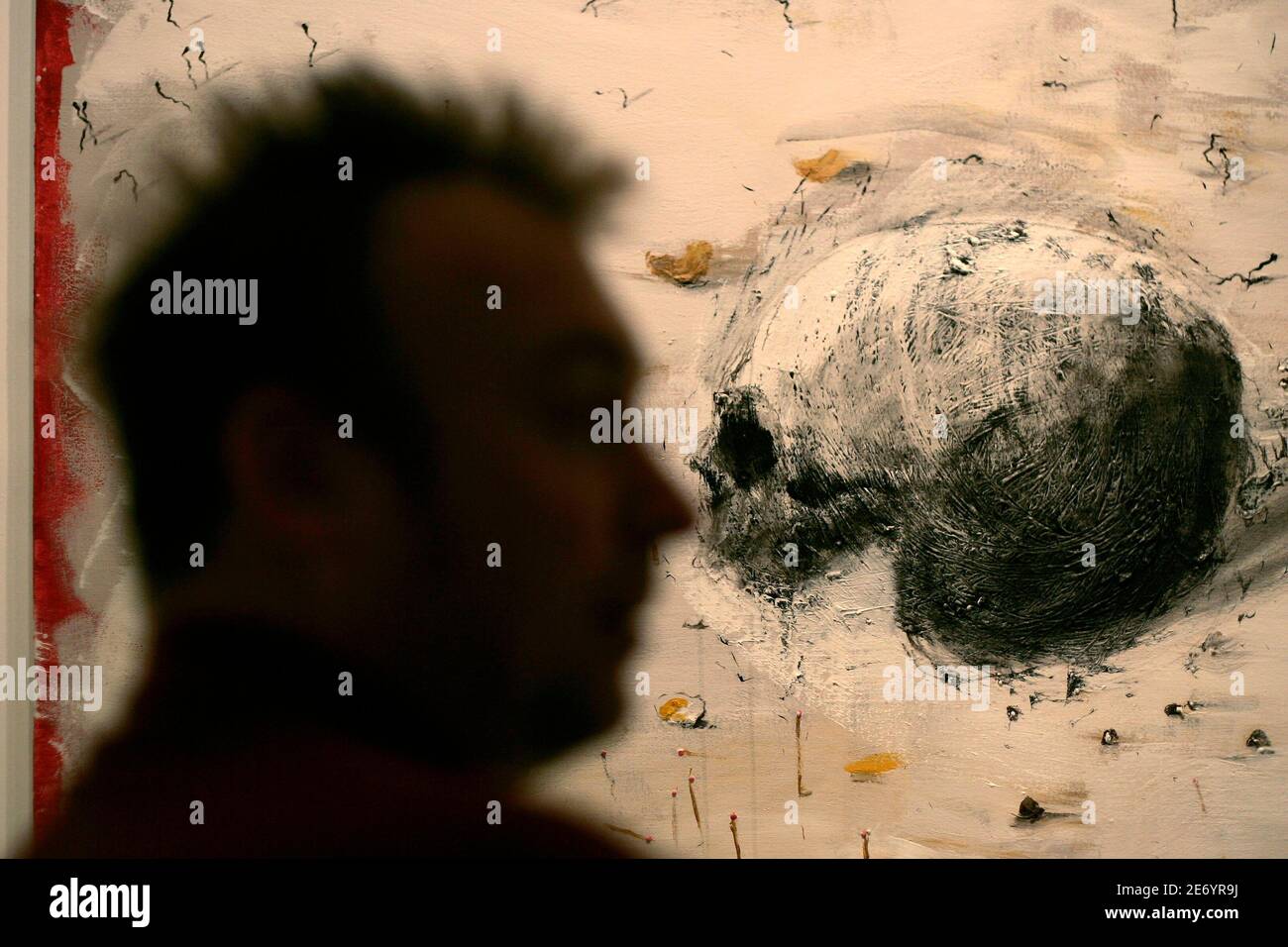 Spanish artist Miquel Barcelo is silhouetted next to his work 'Crane aux Allumettes' during the media preview of his exhibition entitled 'Obra Africana' ('African work') at the Contemporary Art Center in Malaga, southern Spain November 11, 2008. Barcelo' s exhibit will run until February 15, 2009. REUTERS/Jon Nazca (SPAIN) Stock Photo