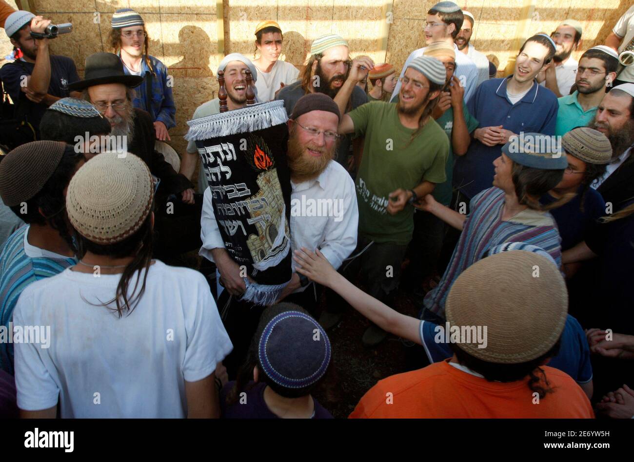 Jewish settlers gather around a torah scroll during the inauguration ceremony of a makeshift synagogue in the unauthorised outpost of Maoz Esther near the Jewish settlement of Kokhav Hashahar, northeast of the West Bank city of Ramallah June 4, 2009, after Israeli authorities demolished similar structures at the outpost on Wednesday. REUTERS/Baz Ratner (WEST BANK POLITICS) Stock Photo