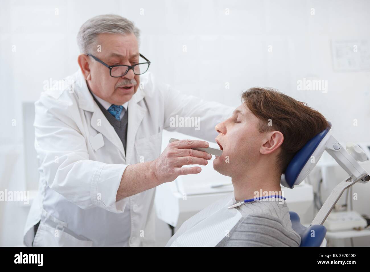 Experienced senior dentist examining teeth of a patient Stock Photo Alamy