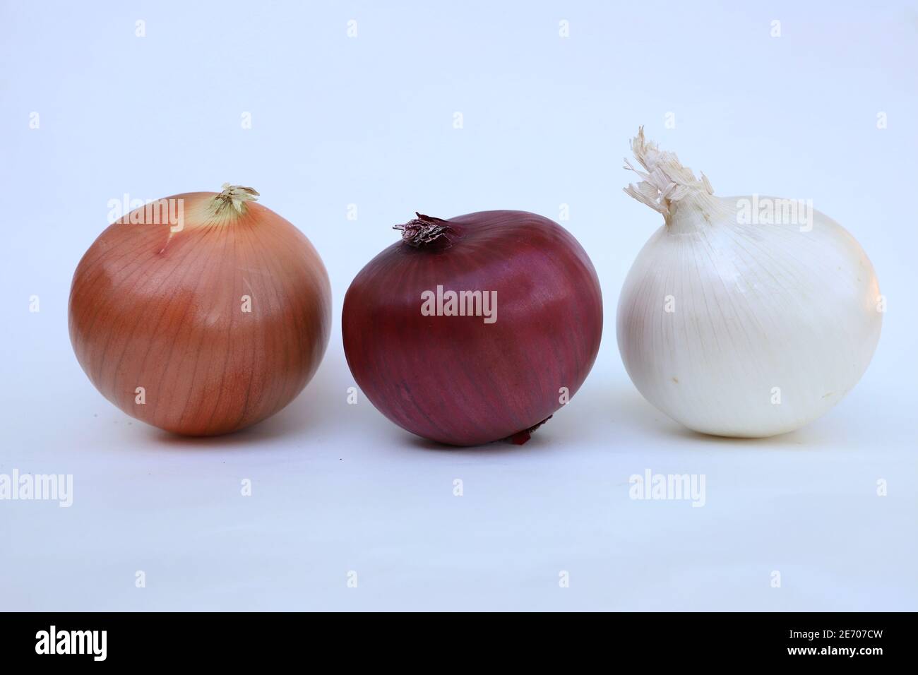 Trio of red, yellow and white onion against a white background Stock Photo