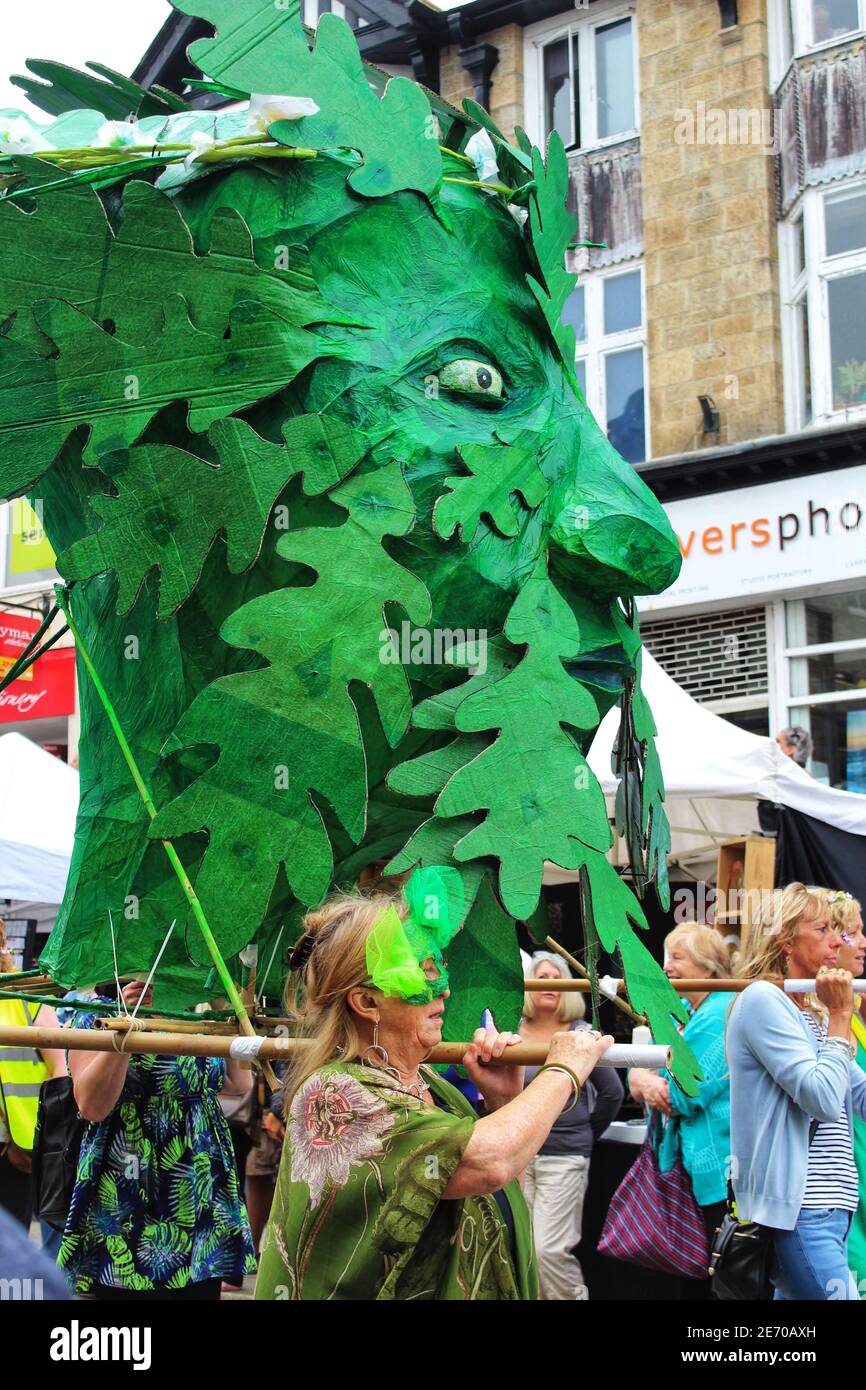 Women carry a paper mache puppet of a green head covered with leaves in the 2019 Mazey day parade as part of Golowan festival in Penzance Stock Photo
