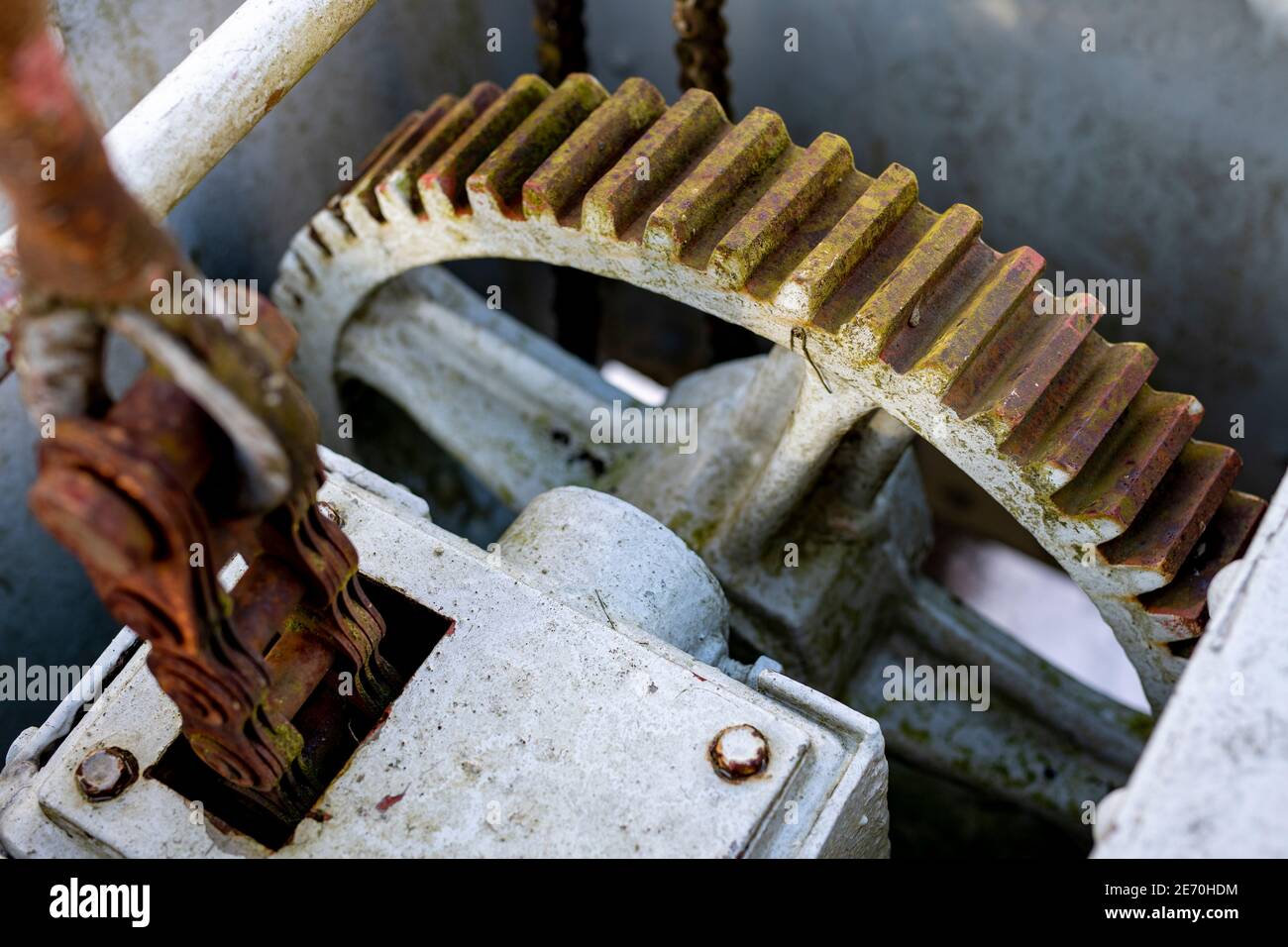 Large gears in an old gearbox. Steel structure to transfer rotational energy. Light background. Stock Photo