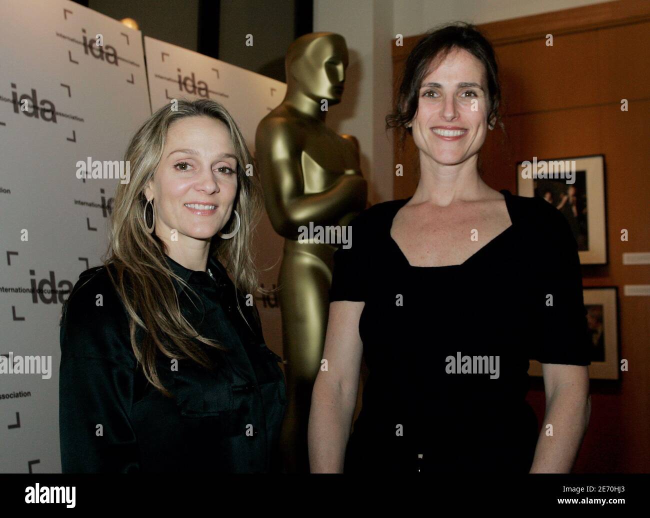 Academy Award nominees for best documentary short subject 'God Sleeps in Rwanda' directors, cinematographers,writers and producers Kimberlee Acquaro (L) and Stacy Sherman poses next to a large Oscar statue during a reception for nominees hosted by the International Documentary Association in Beverly Hills, California March 1, 2006. [The film follows five women who survived the 1994 Rwandan genocide as they work to rebuild their lives. The Academy Awards will be presented March 5 in Hollywood.] Stock Photo