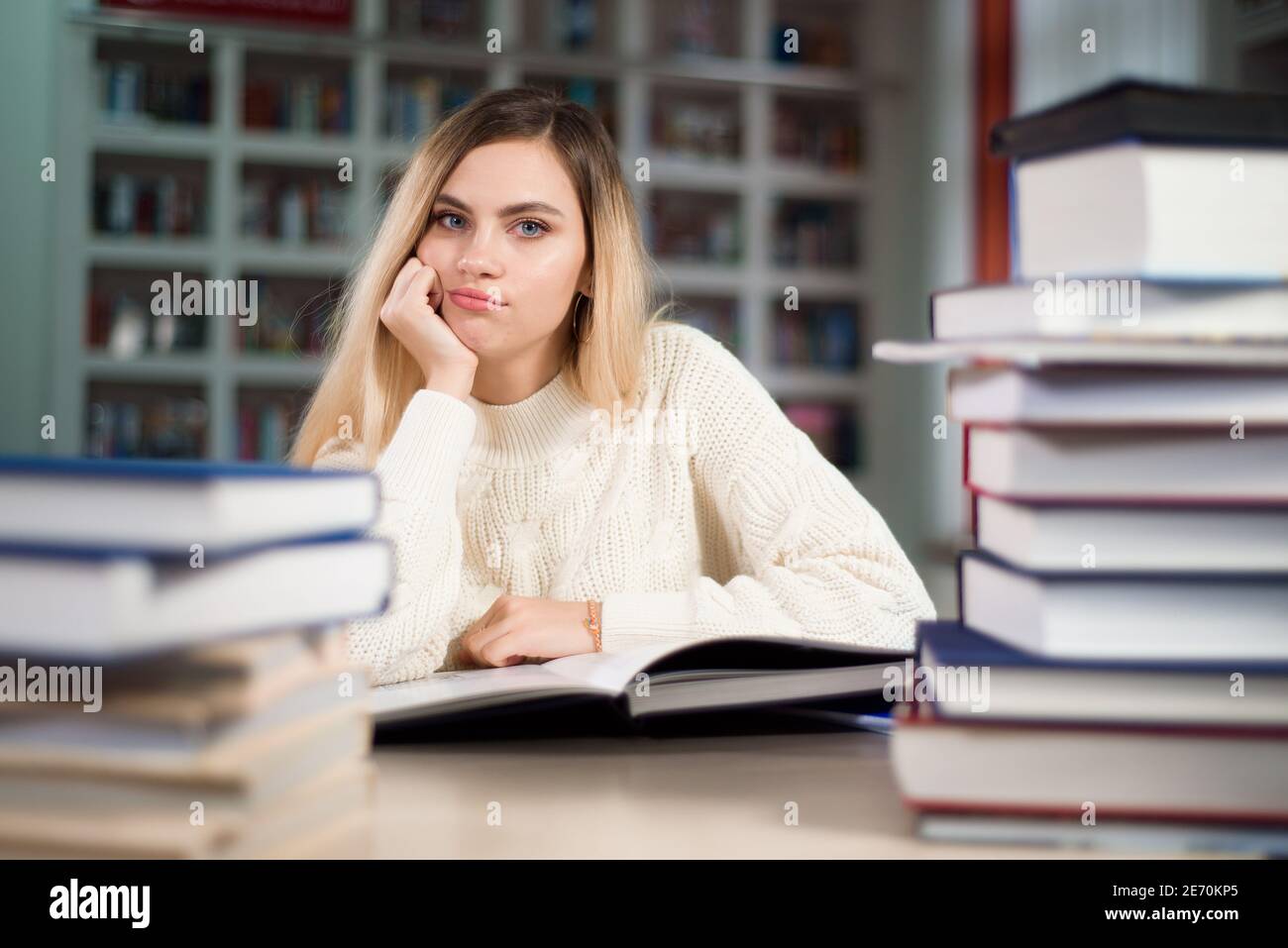 A tired student is studying in the school library Stock Photo - Alamy