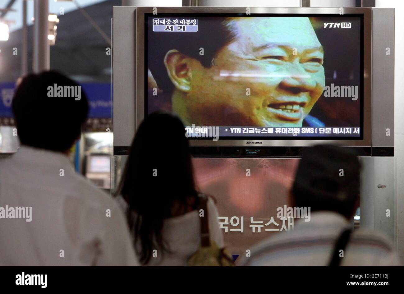 People watch the news on former South Korean President Kim Dae-jung's death at the Seoul railway station August 18, 2009. Former South Korean President Kim, a towering figure in South Korea's struggle for democracy who won the 2000 Nobel Peace Prize for seeking rapprochement with the communist North, died on Tuesday at the age of 85. An official at a Seoul hospital treating Kim for pneumonia confirmed the death.  REUTERS/Jo Yong-Hak (SOUTH KOREA) Stock Photo