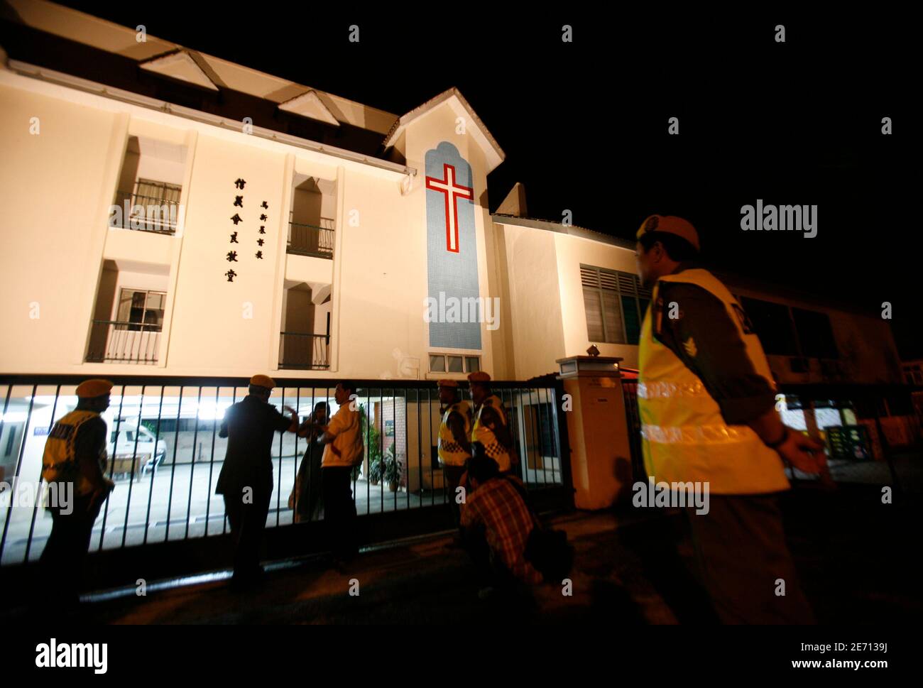 Members of the Volunteers of Malaysian People talk to the security guard of the attacked Good Shepherd Lutheran Church in Petaling Jaya outside Kuala Lumpur early January 13, 2010. Arsonists in Malaysia struck at nine churches and a convent school since Friday amid rising tensions between majority Muslims and Christians over the use of the word 'Allah' to describe the Christian God. The row, over a court ruling that allowed a Catholic newspaper to use Allah in its Malay-language editions, prompted Muslims to protest at mosques on Friday and sparked arson attacks on churches. REUTERS/Bazuki Muh Stock Photo