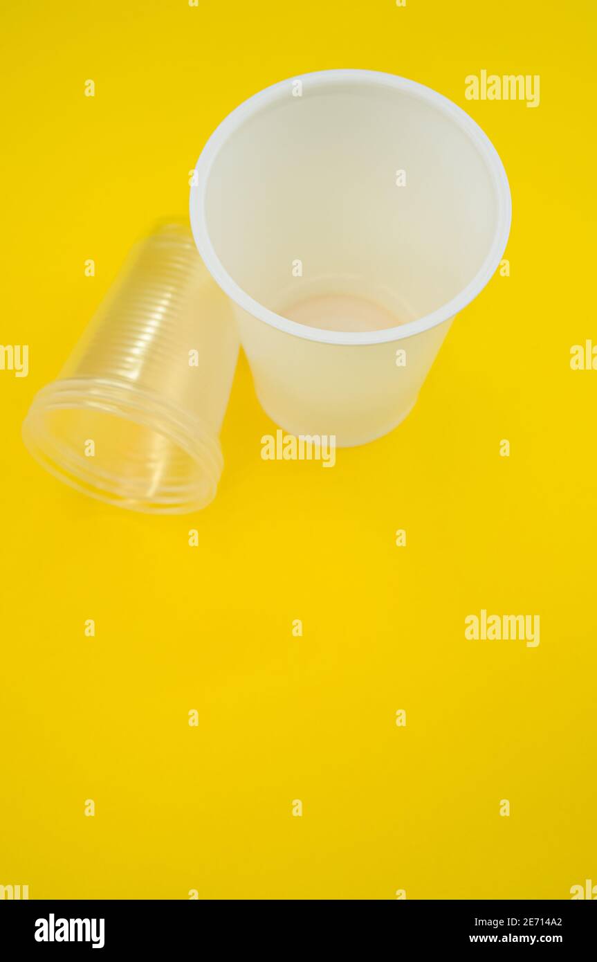 Vertical shot of big and small plastic cups on a yellow surface Stock ...