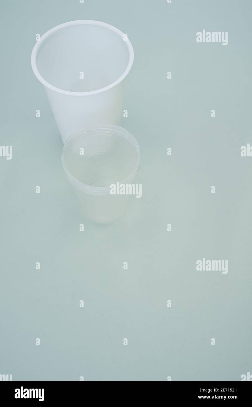 Vertical shot of big and small plastic cups on a bluesurface Stock ...