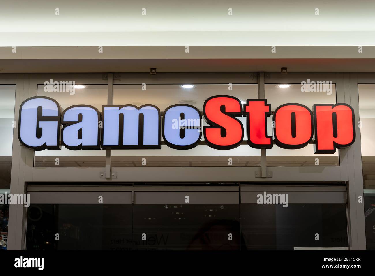 GameStop store front in a shopping center. Big illuminated logo shining during Covid-19 lockdown while the retail shop remains closed. Stock Photo