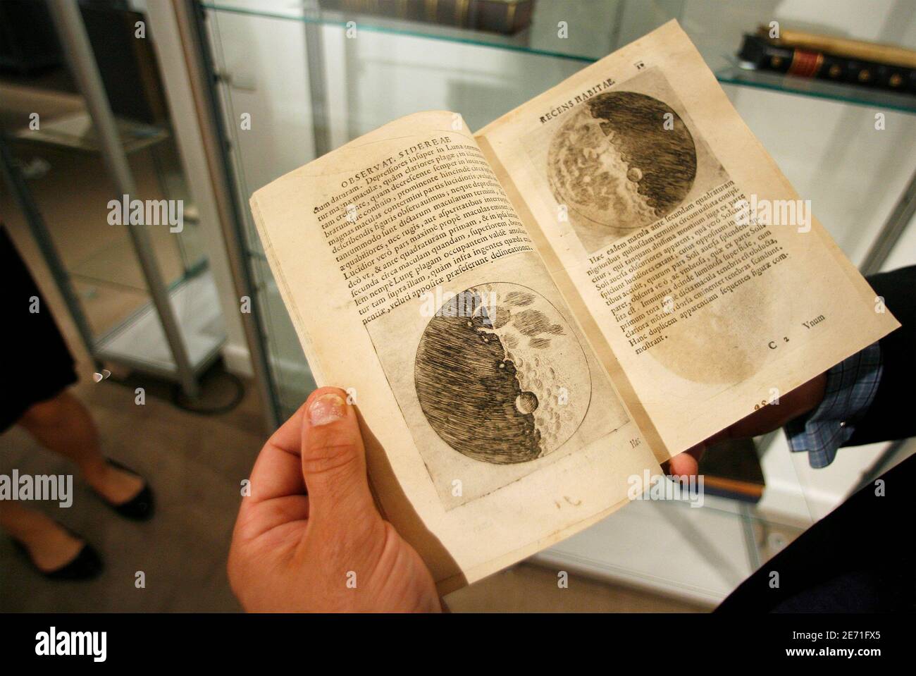 Thomas Lecky, department head of books and manuscripts at Christie's, holds a book with sketches of the moon by Galileo Galilei during a preview at Christie's auction house in New York June 13, 2008. REUTERS/Lucas Jackson (UNITED STATES) Stock Photo