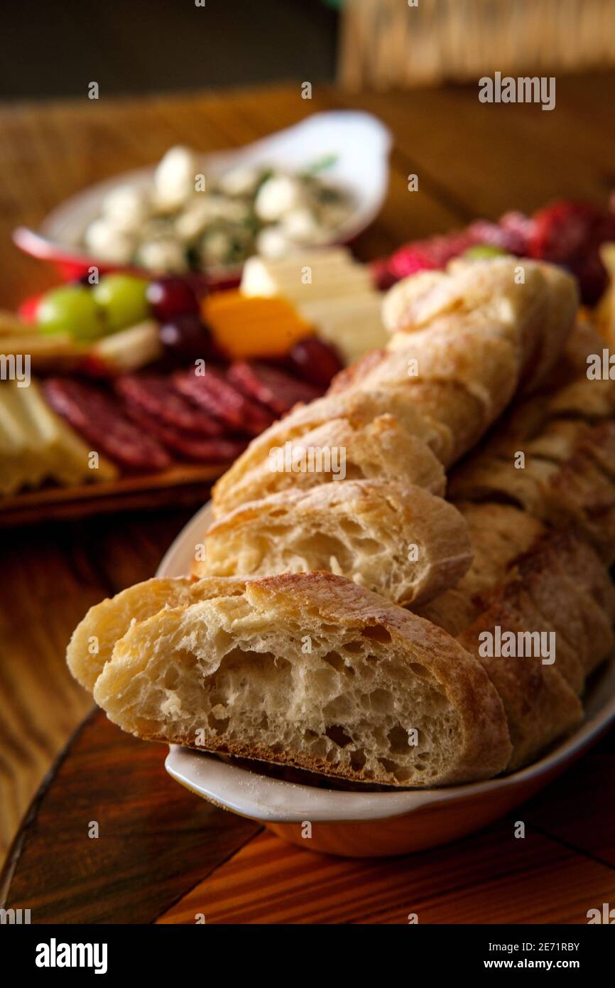 Crusty Italian bread with charcuterie board in background Stock Photo