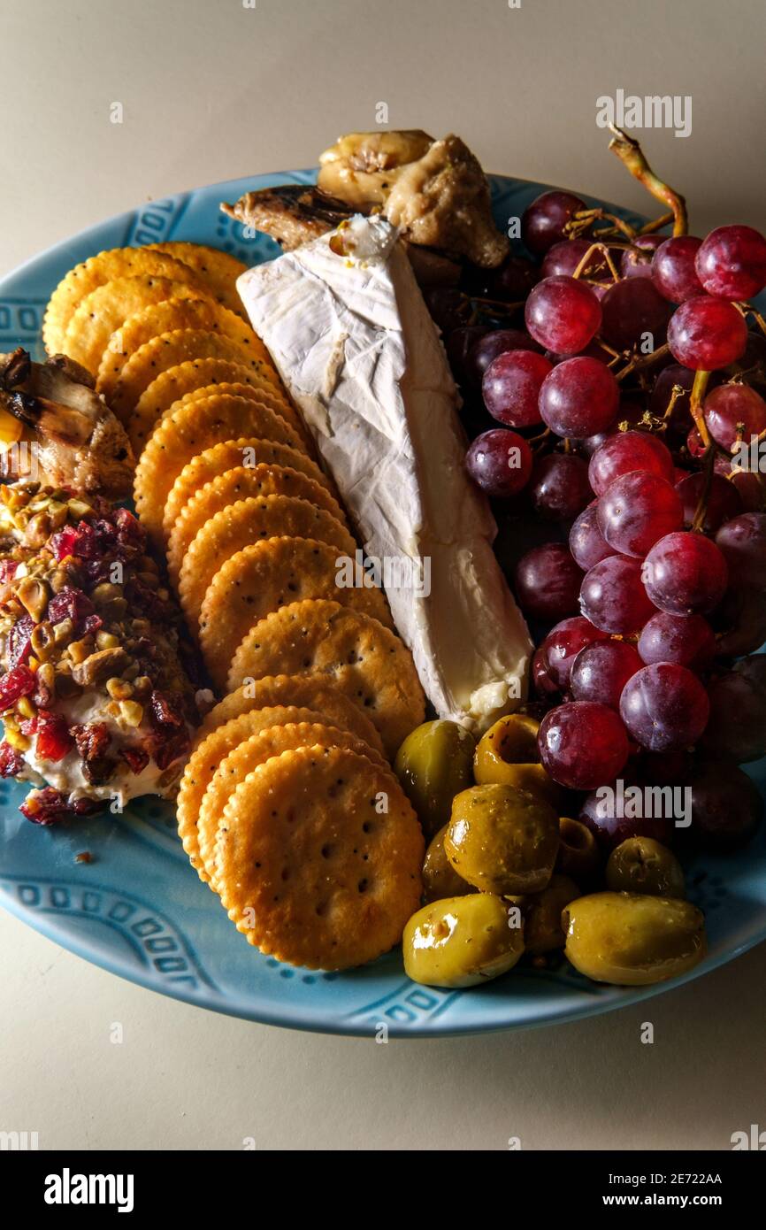 Fancy charcuterie plate featuring crackers cheese and grapes Stock