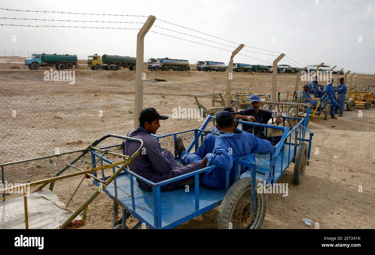 Iraqi porters sit on their carts as they wait for customers overlooking Iran bound oil tankers at the new Zurbatia checkpoint, 120 km (74 miles) southeast of Baghdad November 17, 2007. In a dusty border speck on the map where tanks once fought a bitter war in a brutal landscape, trucks now stretch to the horizon, a sign of growing contact between former blood enemies. Picture taken November 17, 2007. To match feature IRAQ/BORDER     REUTERS/Erik de Castro (IRAQ) Stock Photo