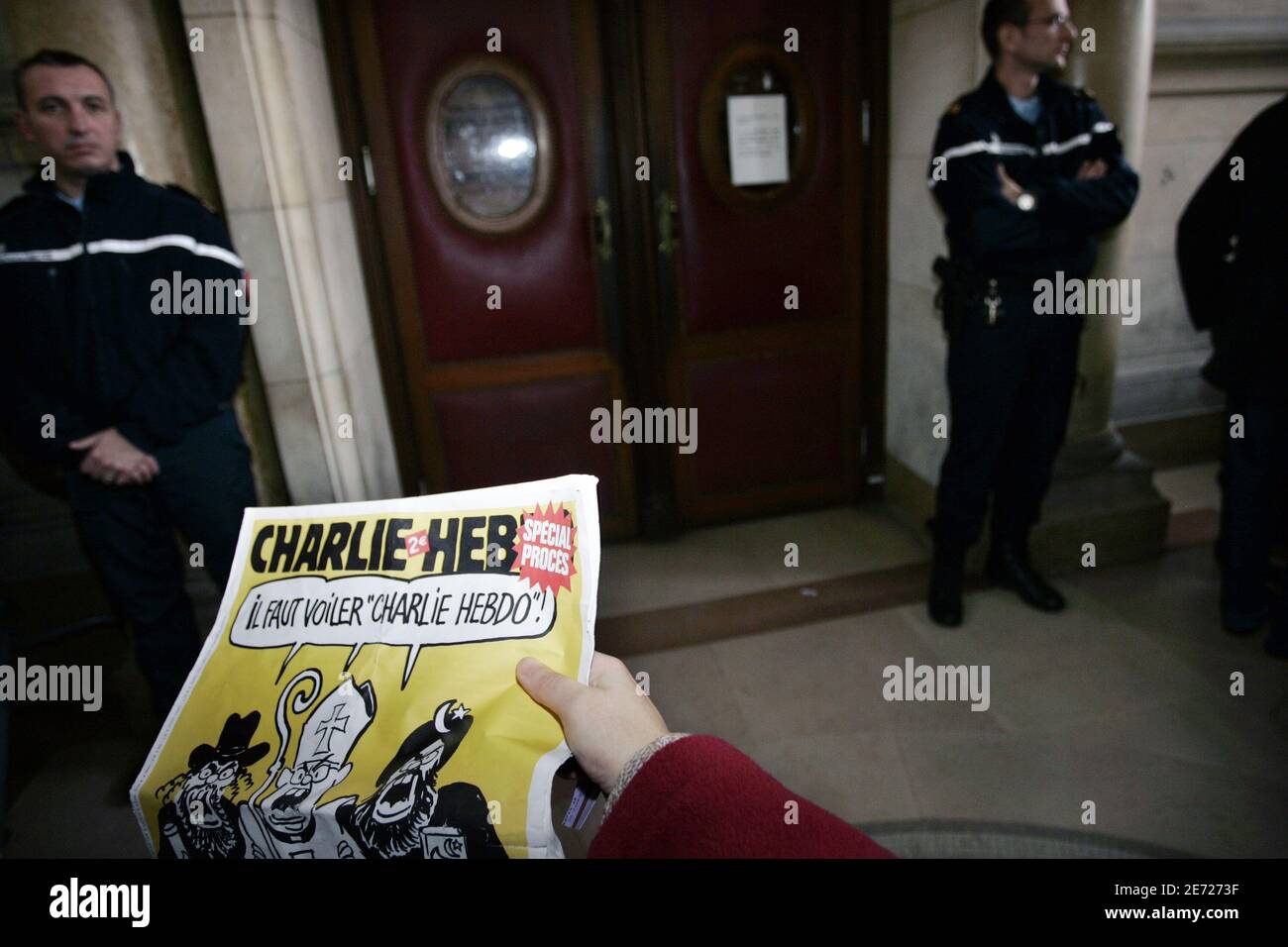 Someone reads Charlie Hebdo at the Court of Paris during the lawsuit against Charlie Hebdo, French satirical weekly magazine which printed cartoons of the Prophet Muhammad, in Paris, France on February 8, 2007. Photo by Thibault Camus/ABACAPRESS Stock Photo