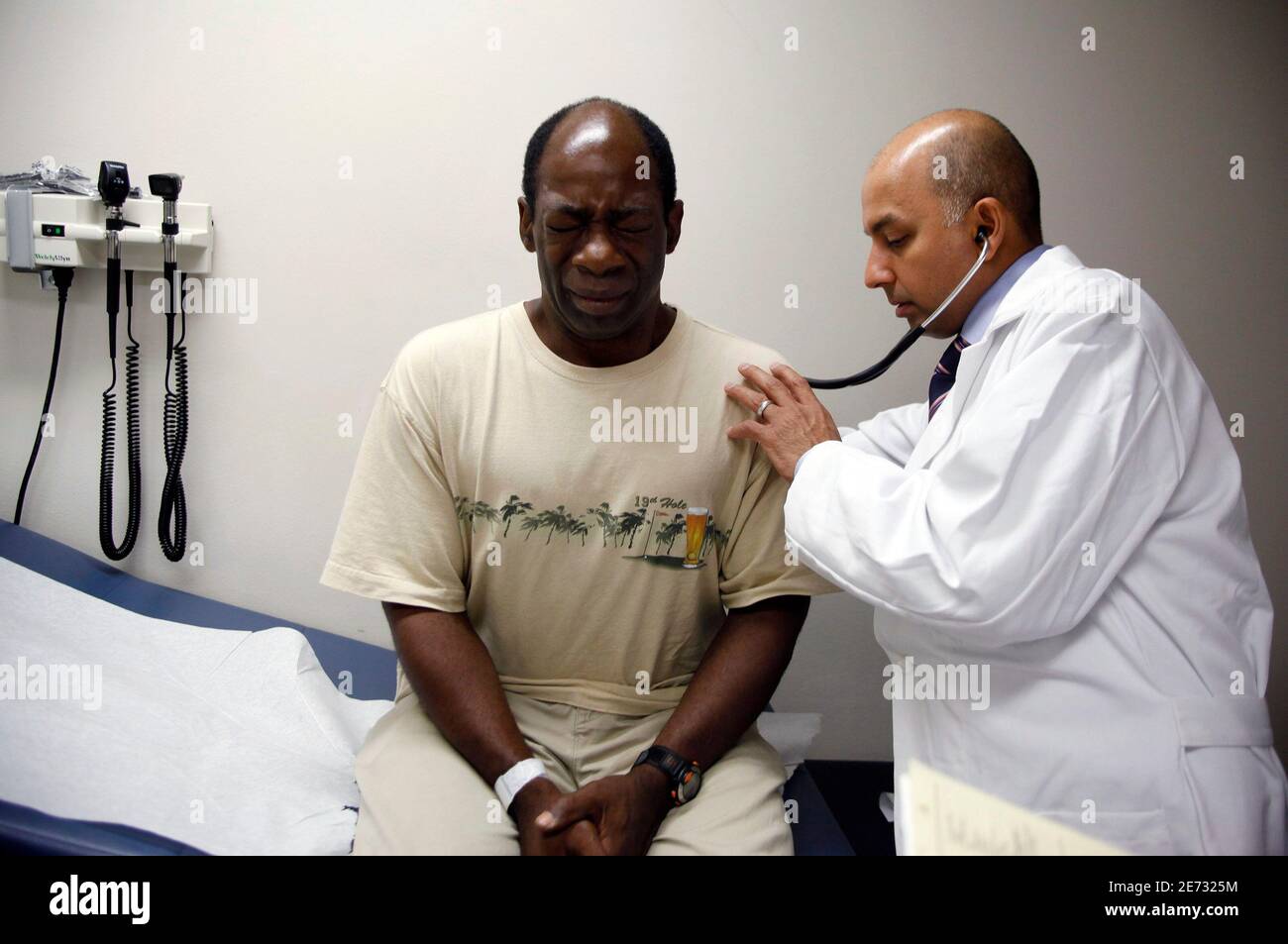 Ernest Sass, 52, (L) winces as he is attended to by Girish Bobby Kapur, M.D. (R) in a room used to see patients who don't require treatment for trauma inside the emergency room at Ben Taub General Hospital in Houston, Texas July 27, 2009. Houston, the fourth-largest American city, is a case study in the extremes of the U.S. healthcare system. It boasts the immense medical center that offers top-notch care at its 13 hospitals, but also has a higher ratio of uninsured patients than any major U.S. city: about 30 percent. To match feature USA-HEALTHCARE/TEXAS REUTERS/Jessica Rinaldi (UNITED ST Stock Photo