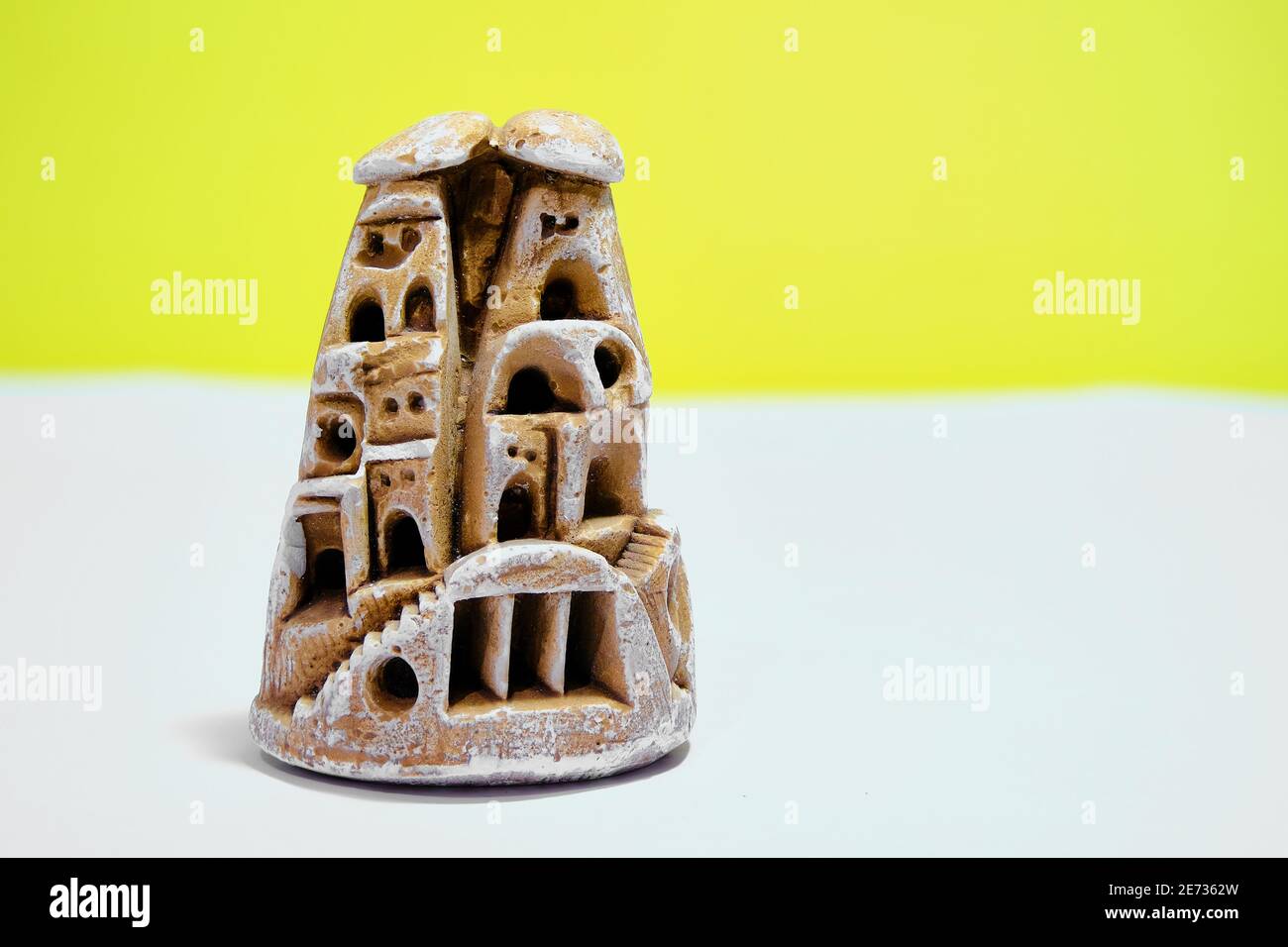 Miniature fairy chimney trinket made of gypsum block. Isolated yellow