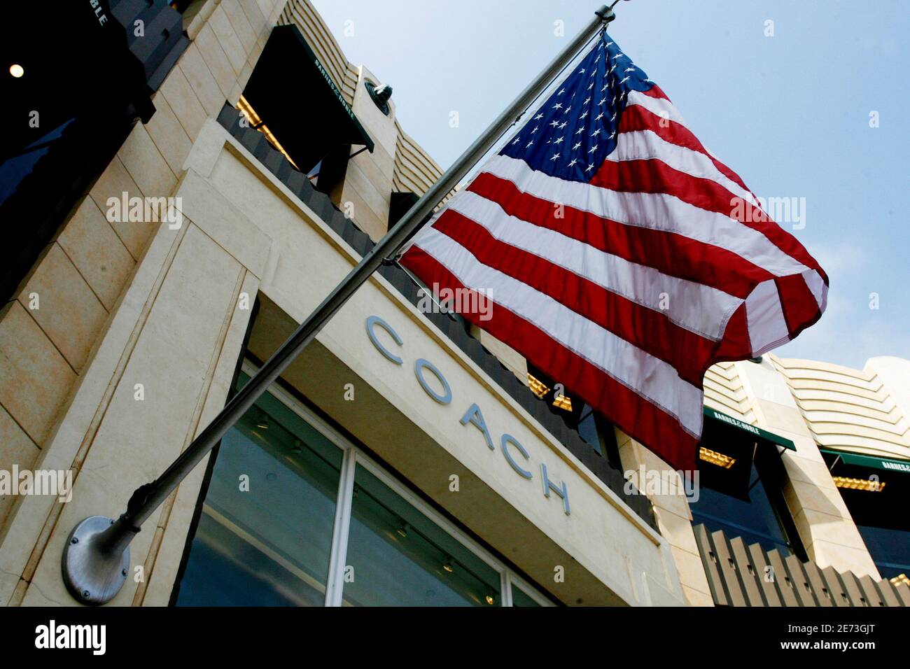 An American flag flies at a Coach Inc. full-price store in Los Angeles, California  July 29, 2008. Coach Inc reported higher quarterly profit on Tuesday in line with Wall Street estimates, and its shares rose as its outlook was not as bad as some analysts had feared. REUTERS/Fred Prouser        (UNITED STATES) Stock Photo