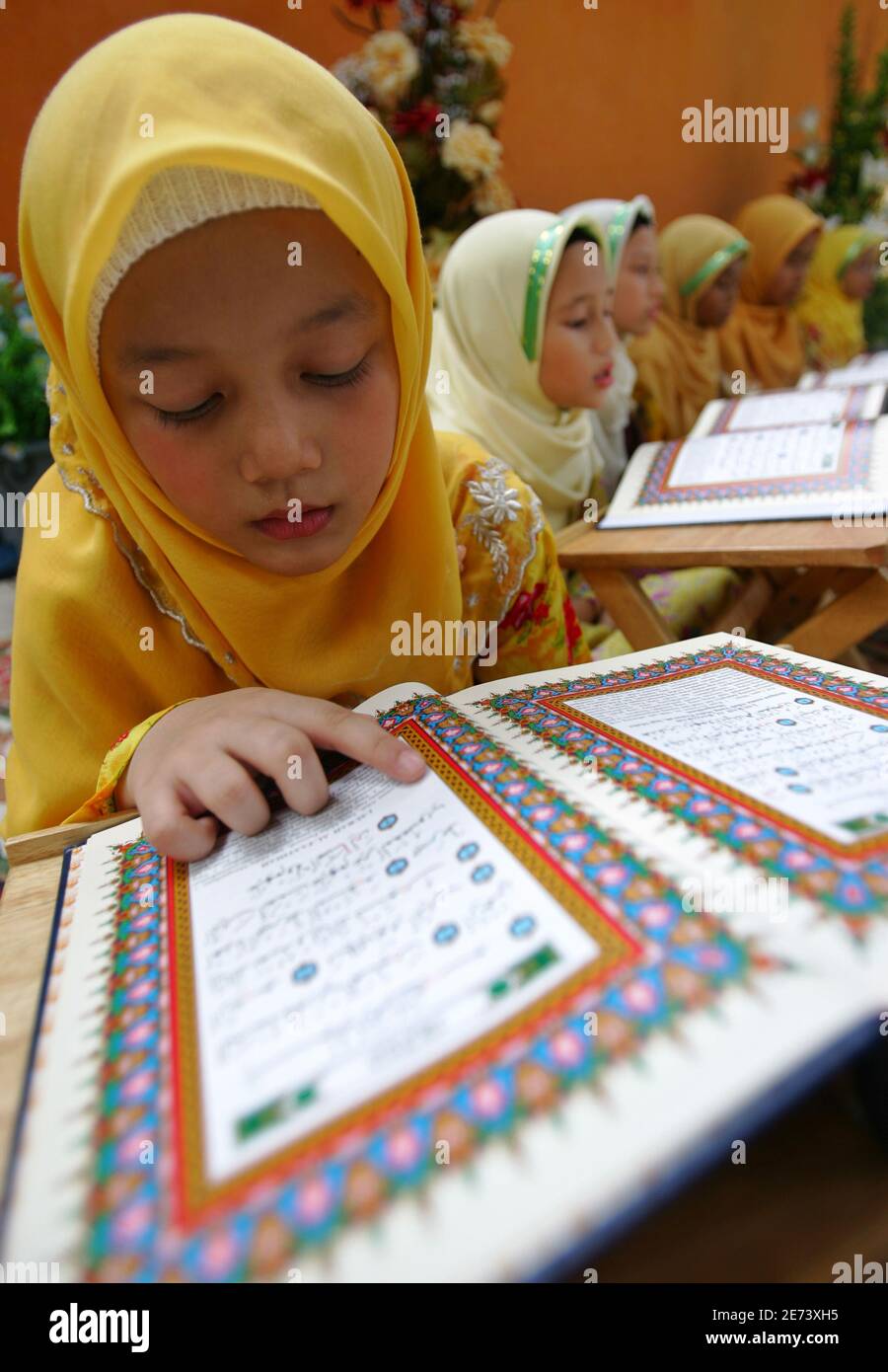 Malaysian Muslim, Wulidalhuda Fathul Muen, 7, recites the Koran during 'Tadarus al-Koran', a ceremony marking the end of a month-long Koran special recital, in Putrajaya outside Kuala Lumpur October 19, 2006. Muslims around the world celebrate Lailatul Qadar, 'the night of power predestination', which is described in the Koran as 'a night better than a thousand months'. Devotees believe Lailatul Qadar occurs in the last 10 nights of the fasting month of Ramadan, which in Malaysia began either on October 13 or 14, depending on the sighting of the upcoming new moon of Syawal.  REUTERS/Bazuki Muh Stock Photo