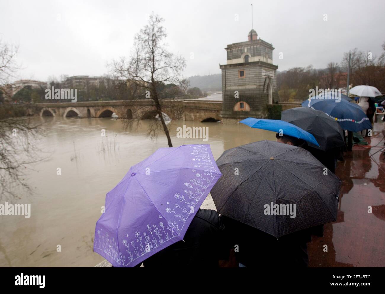Pedestrians watch Milvio Bridge as Tiber river flows in downtown Rome December 12, 2008. Rome braced for the Tiber river to follow the smaller Aniene in bursting its banks on Friday, after days of rain and thunderstorms. Rome's mayor has declared a state of emergency after severe storms early on Thursday flooded underpasses, disrupted train and flight services and killed one person.   REUTERS/Alessandro Bianchi        (ITALY) Stock Photo