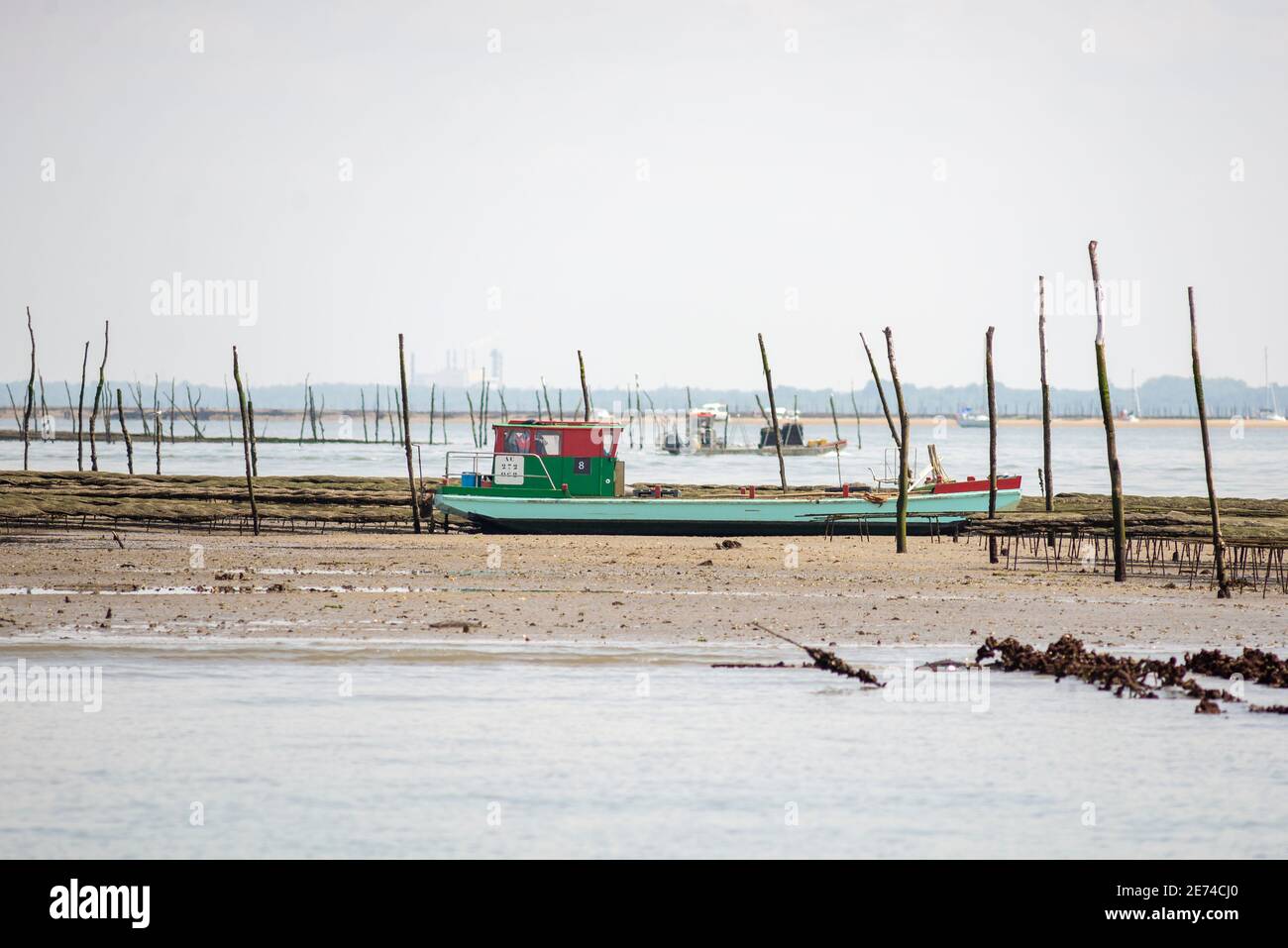 A colorful barge is lying on a sand bank among oyster traps in the Bassin d'Arcachon, Gironde, France Stock Photo