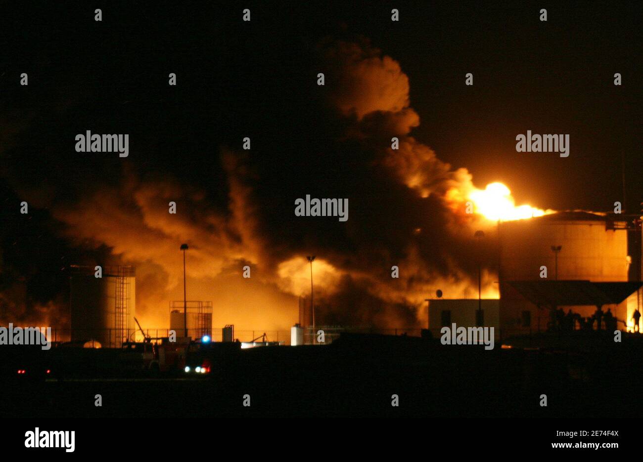 Albanian firefighters try to contain a fire at a fuel depot in the port city of Shengjin, some 70 km (44 miles) northwest of the capital Tirana, December 17, 2006. Firefighters worked all Sunday using retardant foam water and sand to prevent the fire from spreading to two bigger depots. REUTERS/Arben Celi Stock Photo