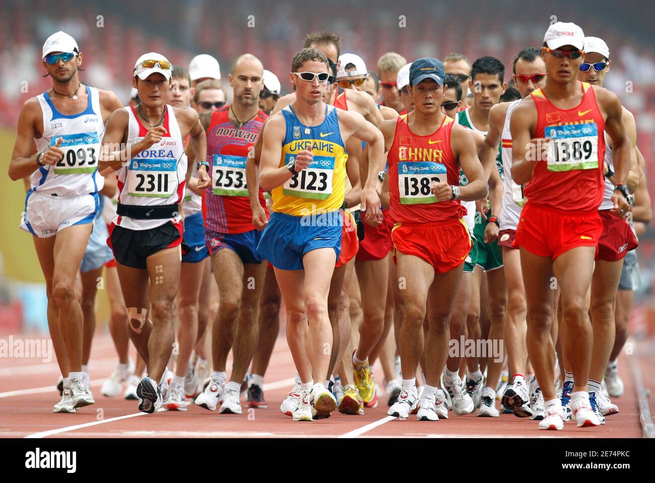 Competitors walk down the main straightaway during a lap of the National  Stadium at the start of the men's 50 kilometer race walk at the Beijing  2008 Olympic Games August 22, 2008.