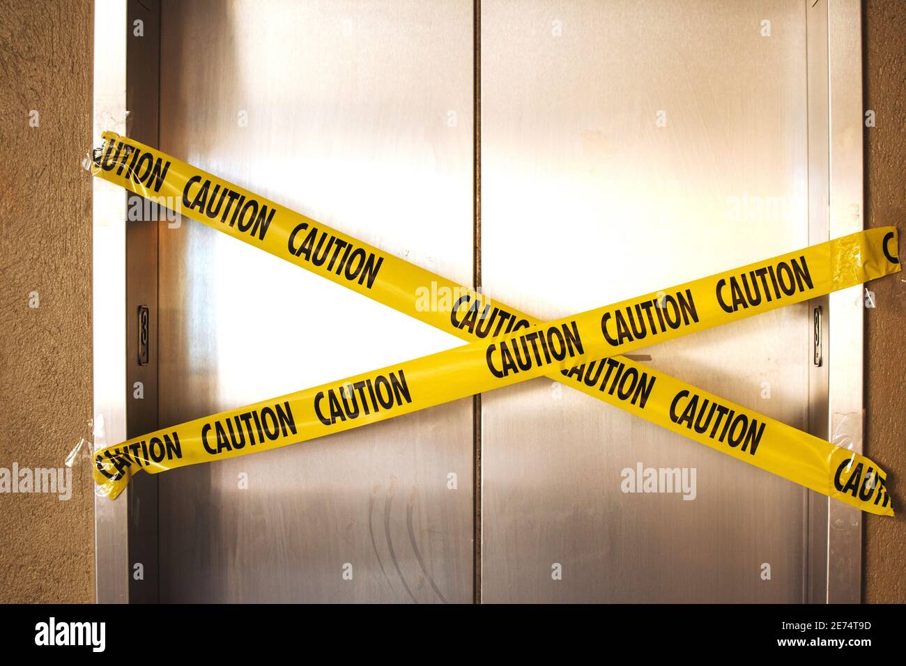 Broken elevator with warning sign, yellow caution tape on stainless