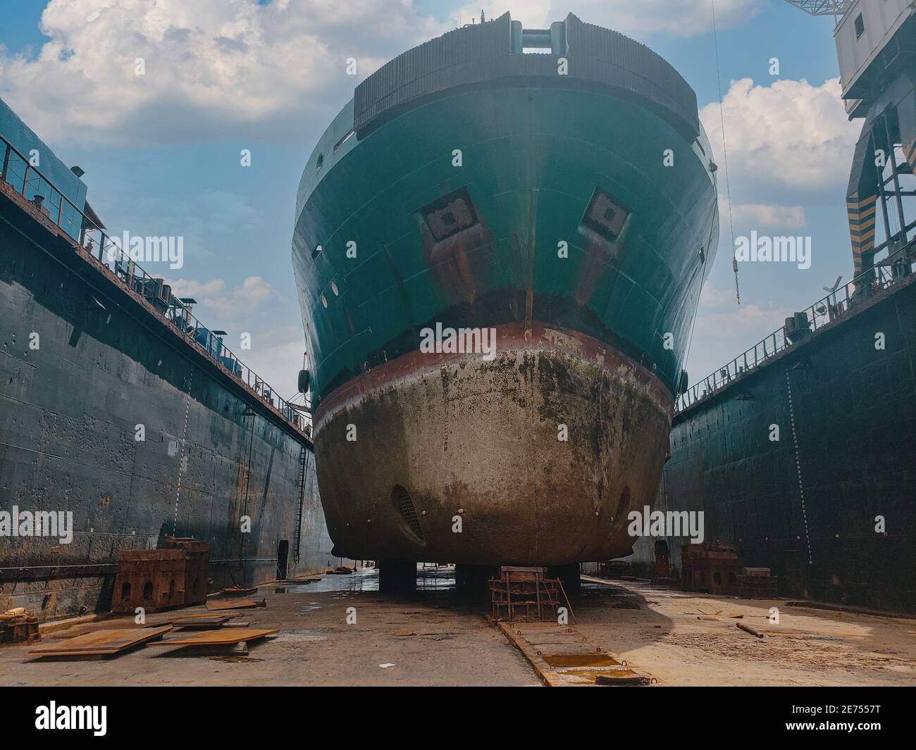 Industry view Ocean Vessel in the dry dock in shipyard. Old rusty ship under repair Stock