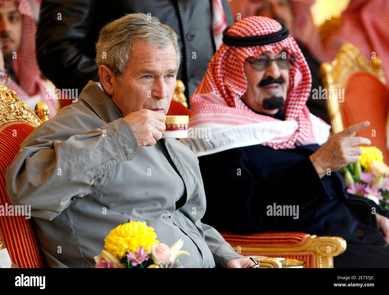 U.S. President George W. Bush sips his drink as Saudi King Abdullah makes a point while some of the King's finest horses are paraded before Bush during his visit to Al Janadriyah Farm in Al Janadriyah, Saudi Arabia January 15, 2008. The farm is the King Abdullah's  personal country and weekend retreat.        REUTERS/Kevin Lamarque   (SAUDI ARABIA) Stock Photo