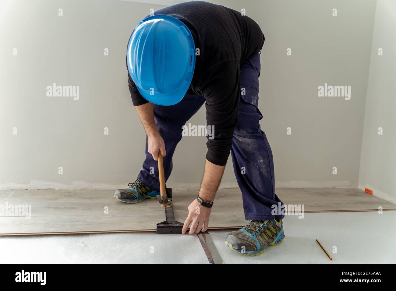 Carpenter worker installing laminate flooring in the room. Stock Photo