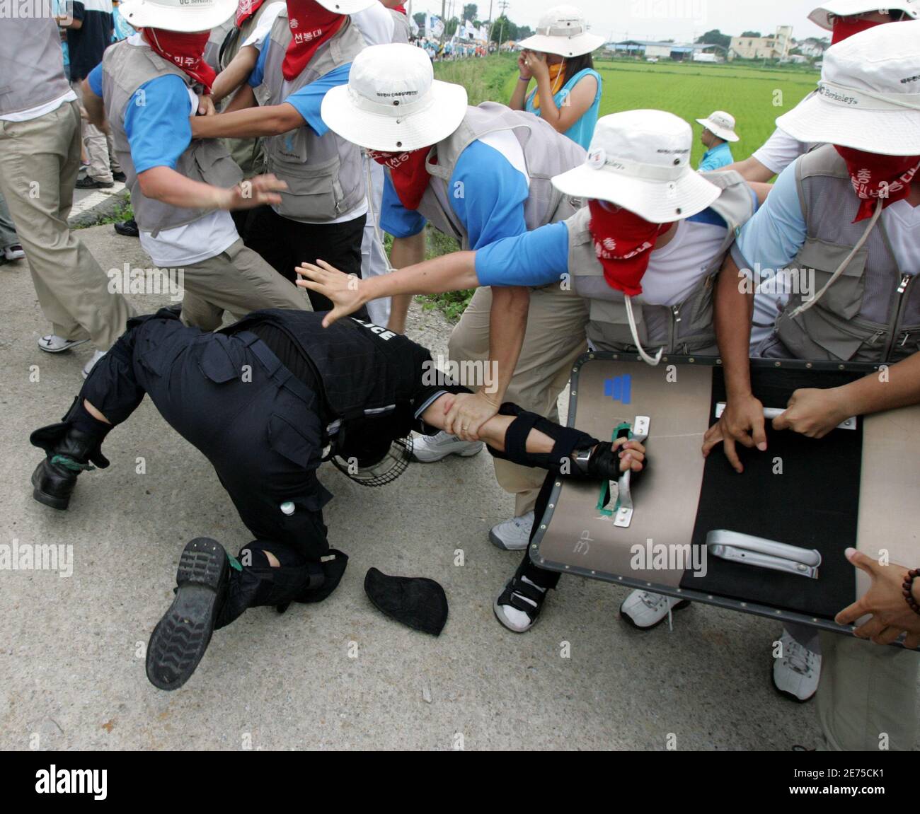 Protesters detain a riot policeman as police use shields and clubs to stop protesters trying to enter U.S. army's Camp Humphreys in Pyongtaek, South Korea. Protesters detain a riot policeman as police use shields and clubs to stop the protesters trying to enter the U.S. army's Camp Humphreys in Pyongtaek, about 80 km (50 miles) south of Seoul, August 8, 2005. About 500 South Korean protesters from labour unions and college students' groups rallied near the U.S. army base on Monday as they demanded U.S. forces leave the country, which they insist block the reunification of the two Koreas. REUT Stock Photo