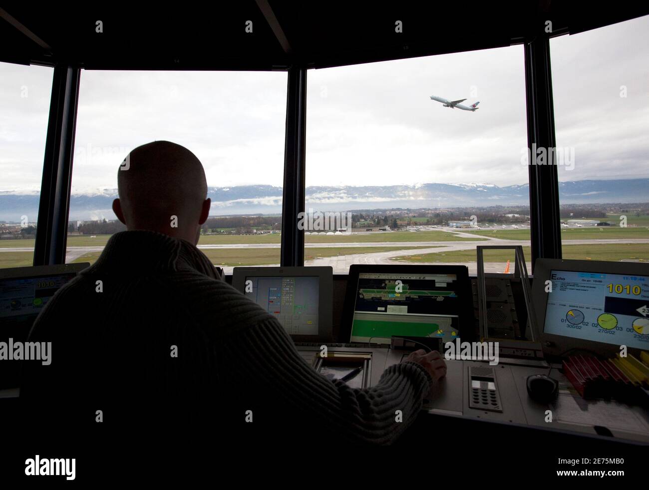 An operator of Swiss air traffic control firm Skyguide monitors airplanes  ground traffic and take off at Cointrin airport in Geneva December 3, 2009.  The control tower, nicknamed because of its shape