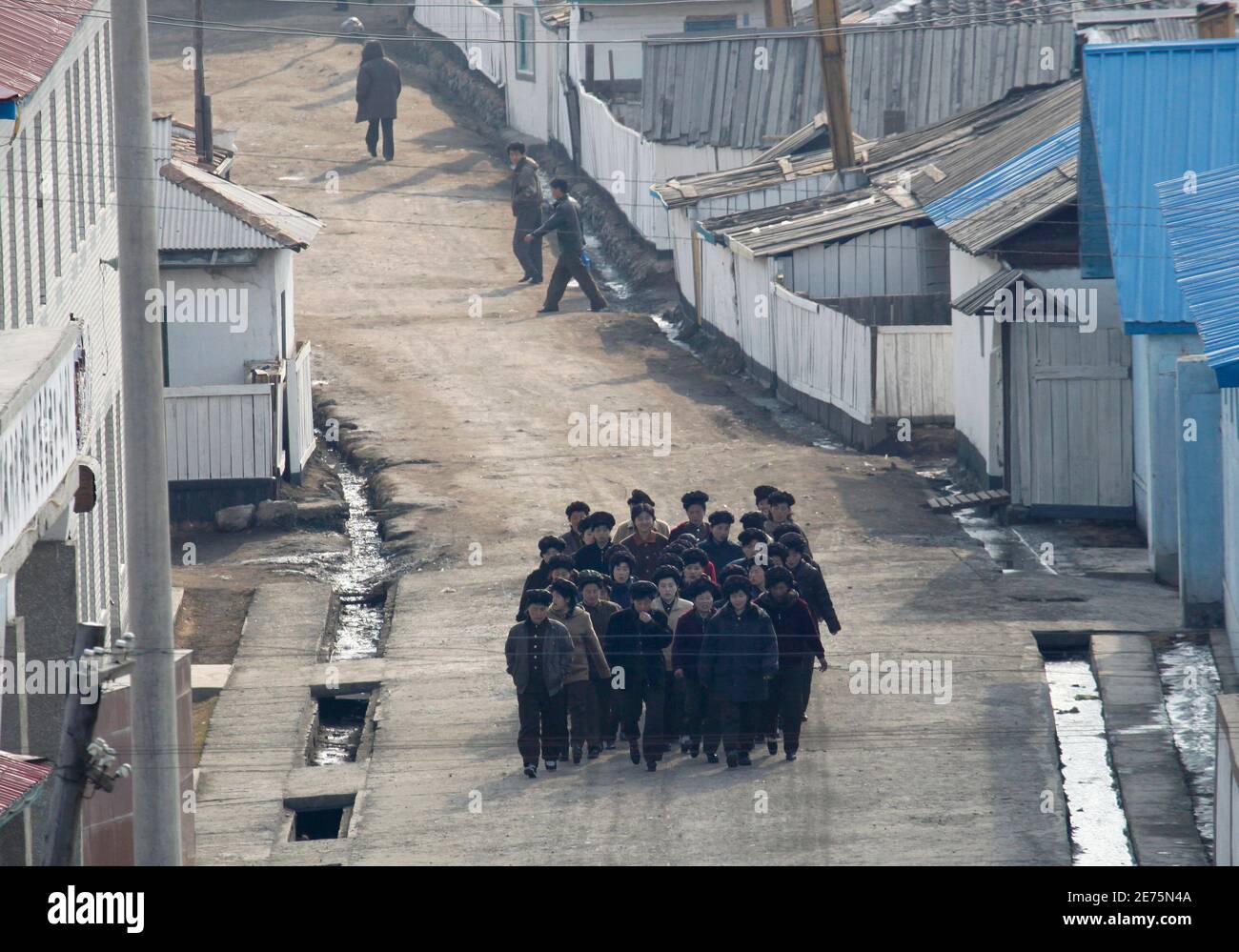 North Korean workers walk towards a factory in the North Korean city of