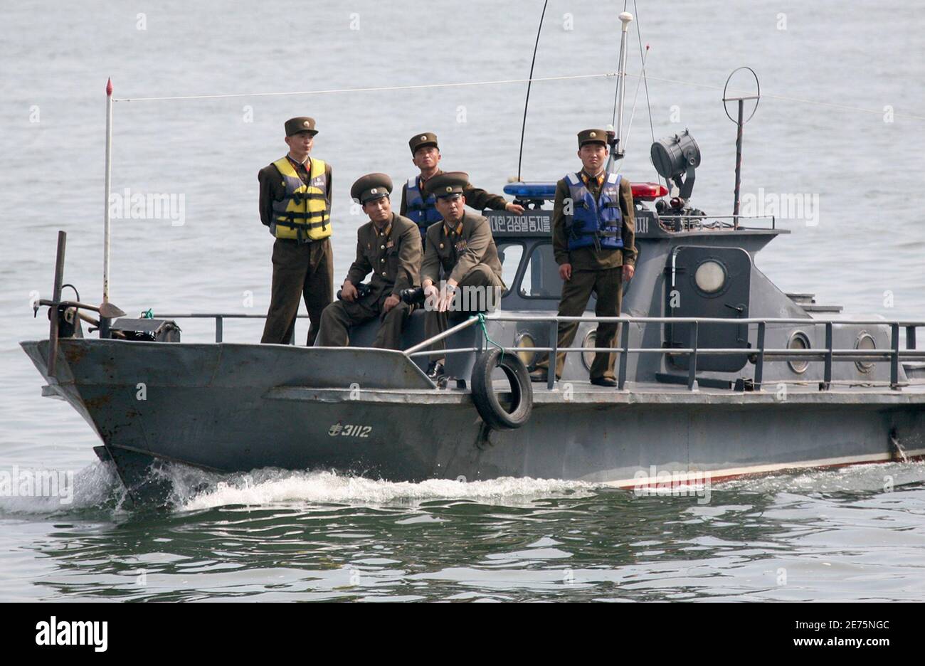 North Korean soldiers patrol on a military boat on the Yalu River near the North Korean town of Sinuiju, opposite the Chinese border city of Dandong, June 14, 2009. North Korea said on Saturday it would start a uranium enrichment program and weaponize all its plutonium in response to fresh U.N. sanctions, which the United States said it would work vigorously to enforce. Pyongyang also threatened military action if Washington and its allies tried to isolate it. REUTERS/Jacky Chen (NORTH KOREA MILITARY POLITICS) Stock Photo