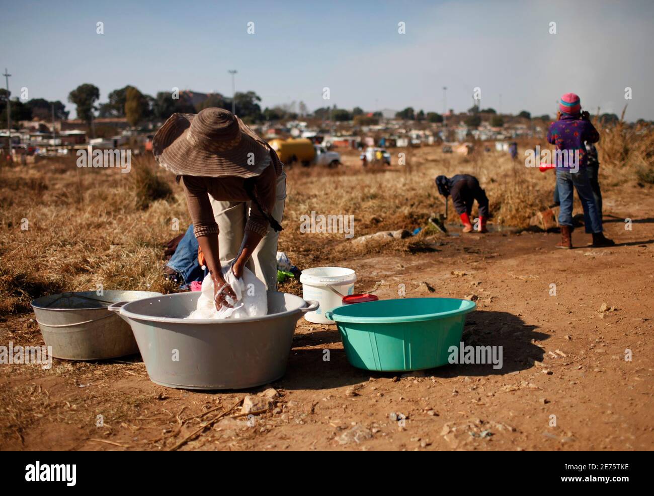 A woman washes her laundry at a street in Soweto in Johannesburg June