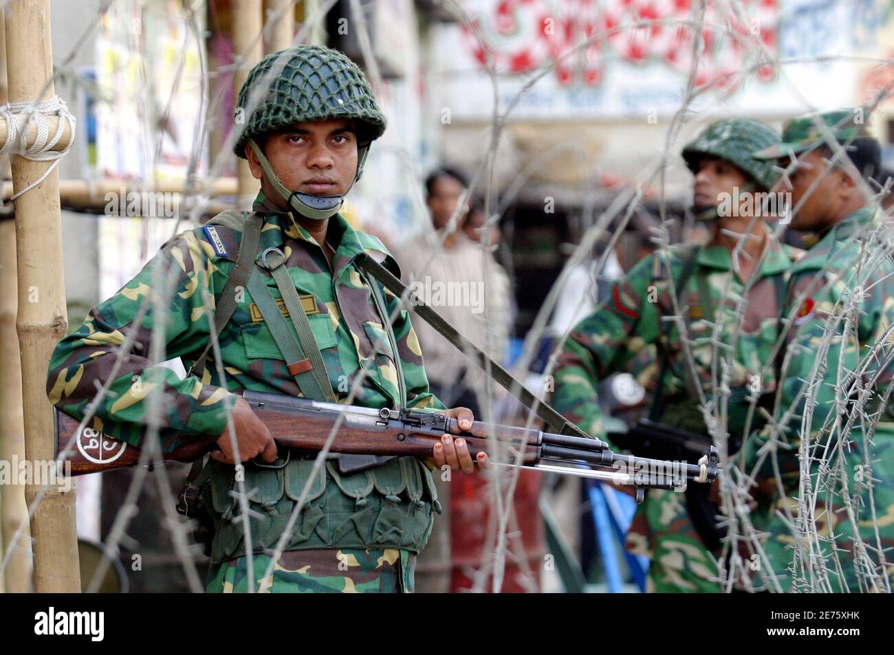 Soldiers stand guard behind barbed wire at Purana Palton in Dhaka December  13,2006. Bangladesh's political crisis deepened on Wednesday after a  multi-party allience contestinag next month's parliamentary polls rejected  moves to settle