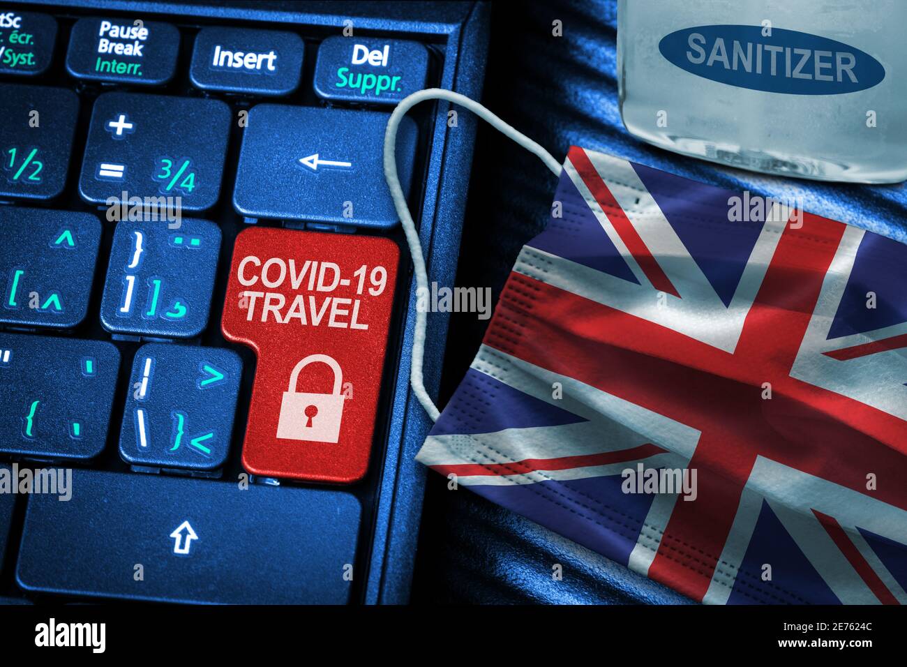 UK COVID-19 coronavirus travel restrictions concept showing red button warning on keyboard with British flag face mask and hand sanitizer. New normal Stock Photo