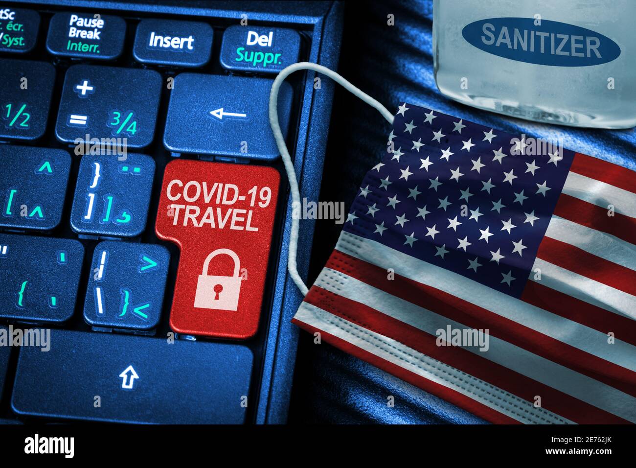 US COVID-19 coronavirus travel restrictions concept showing red button warning on keyboard with American flag face mask and hand sanitizer. New normal Stock Photo
